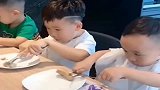 个熊孩子用叉子吃东西，哥哥一看就是老手，弟弟尴尬了
