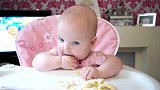 六个月的小宝宝坐在餐椅里吃着东西，这模样超级萌啊！