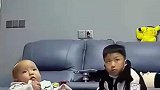 哥哥陪弟弟一起看电视，不小心把弟弟踢倒，妈妈听到后赶紧跑来