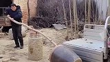 男子利用杠杆原理，将水缸放在三轮车上