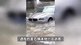 宝马车遇涨潮熄火落海，岸上众人“拔河式”拖车，合力拉绳摔个仰天跤