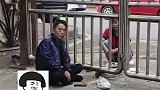 丈夫隔着小区铁门席地而坐，陪妻子吃饭