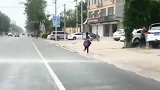 小朋友背书包与洒水车欢乐赛跑，最后还是被超过了