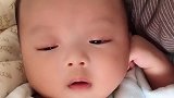 萌娃快要睡着了，眼睛都快眯成一条缝了
