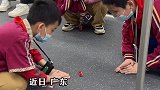 地铁里小朋友趴在地上玩游戏，小朋友的世界就这么简单