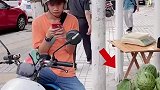 男子在路边玩手机，莫名其妙买下了一个西瓜