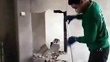 工人抡锤砸墙，将门框的位置砸开
