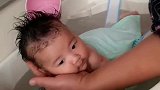 小宝宝洗澡的时候，妈妈给宝宝身上倒水，宝宝的表情萌翻了