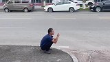 小伙路边玩手机，然后