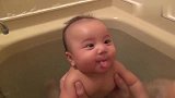 小宝宝和爸爸一起洗澡，爸爸一吹气小宝宝边笑边伸小舌头，萌翻了