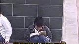 下课了同学们都在玩耍，小男孩一个人坐在墙边，安安静静看书