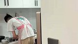 男子在厨房里边刷碗边唱歌