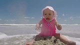 小萌娃在海滩上玩沙子正起劲，下一秒海水涨潮，这表情没谁了