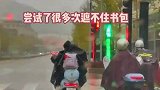 孩子试图用雨衣遮住书包，几次失败之后身边突然伸出了一只手