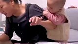 外孙女看见外婆啃甘蔗，上前拽着外婆衣服，直勾勾的盯着甘蔗