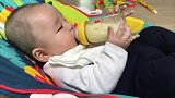小宝宝自己乖乖抱着奶瓶喝奶，这画面怎么看都不够，萌翻！