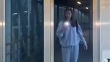 女生站在电梯门前拍照，电梯上升的瞬间停住了