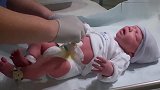 刚出生的小宝宝，护士在给他护理脐带并做检查，看样子好可爱