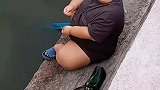 男孩用小鱼竿钓鱼惊呆男子