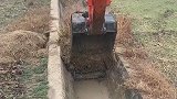 男子开挖掘机清理水道，过程很轻松