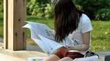 公园看报纸的白哲美女