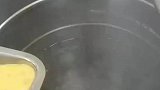 厨师将蛋液倒入热水中，做真正的蛋花汤