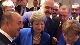 英国首相北约峰会间用手机看世界杯 默克尔还拍肩膀安慰她