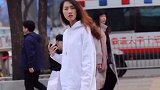北京街拍：气温上升，美女白色卫衣搭配平板鞋气质十足。