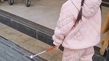 盲人小女孩走在盲道上，路人纷纷伸出援手清理障碍