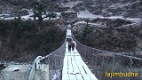 尼泊尔农村妇女冬天背着货进城卖，穿着拖鞋过铁链桥