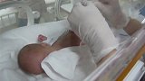 护士给刚出生的早产儿安装检测仪器，宝宝双眼紧闭让人看了好心疼
