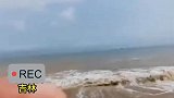 情侣让别人帮忙录像，录像的我拍上了，海浪我也拍上了