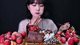 美女试吃圣诞巧克力水果奶油蛋糕、新鲜草莓、黑莓、橘子