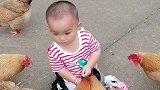 农村的孩子胆子就是大，被鸡包围个居然如此淡定，呆萌的表情可爱