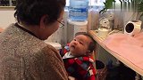 奶奶抱着小宝宝逗趣，享受这天伦之乐