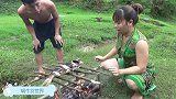 农村情侣户外野炊，草坪上柴火烤大鱼，烤得发黑了，照样吃得很香