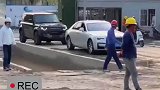 领导开着豪车来工地视察，工人们停下手里的活站在一旁注视着这些从身边开过的豪车
