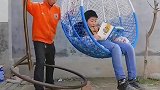 男子将椅子放在石砖上，让男孩坐上去配重