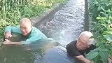 两大爷坐在沟渠中间，用手引导水流方向