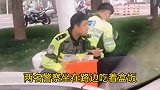 两名警察坐在街头吃盒饭，女孩为他们送上牛奶