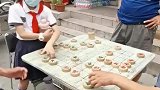 女孩在街头与大爷下象棋，展现出超越年龄的实力