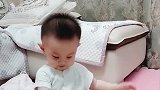 萌宝坐在地上听音乐，小身体随着音乐摆动，可爱爆了