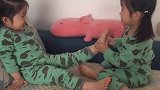 这双胞胎姐妹俩，真是太会玩了，唱着唱着姐姐就吃起妹妹的脚丫