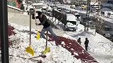 一小伙上屋顶铲雪，连人带雪一块掉下去了，真逗