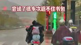 孩子试图用雨衣遮住书包，几次失败之后身边突然伸出了一只手