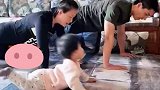 宝宝带着父母一起做跷跷板式俯卧撑