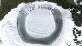 日本八幡平山顶“镜沼”碧水与湖心积雪相映，呈“龙眼”奇景