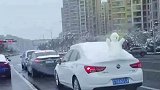 司机带着雪人开上马路，好像在炫耀着自己的战利品