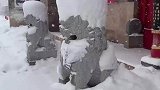 女子看见石狮子，因为下雪头上都是积雪