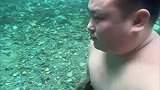 男子夹着石头，在河底漫步